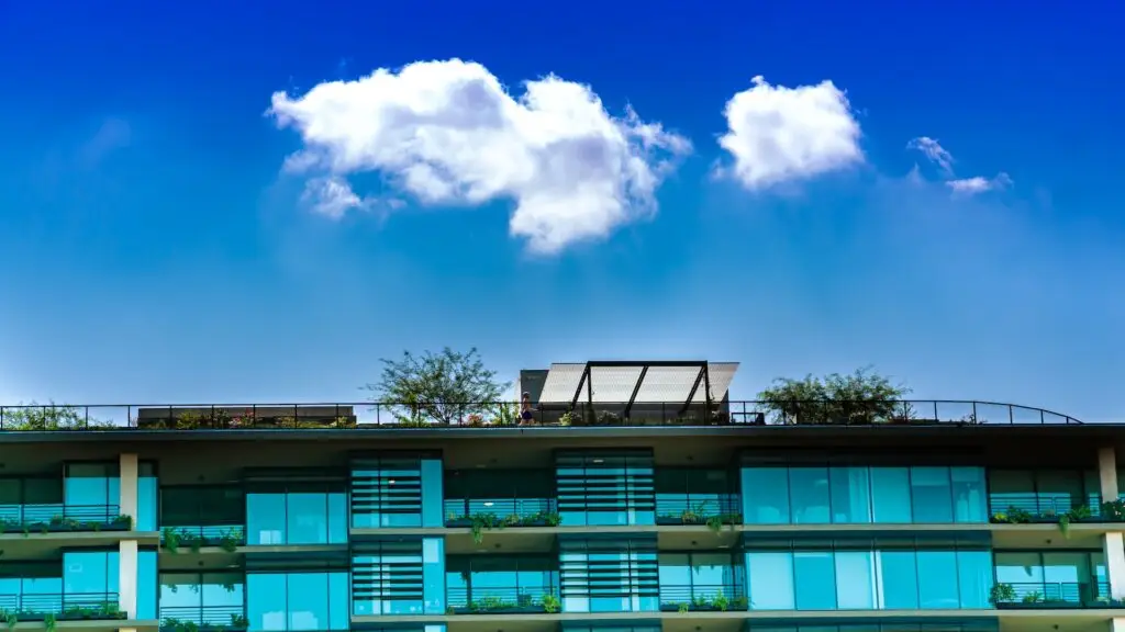 a building with a balcony and trees on the roof