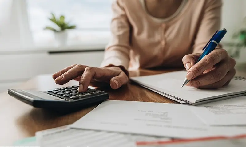 a person using a calculator and a pen