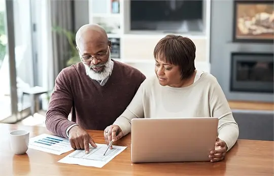 a man and woman looking at a laptop