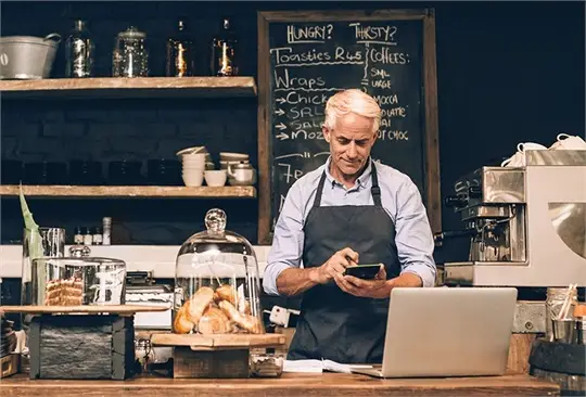 a man in an apron holding a phone